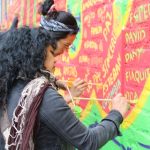 Dos mujeres pintando mural de memoria