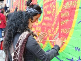 Dos mujeres pintando mural de memoria