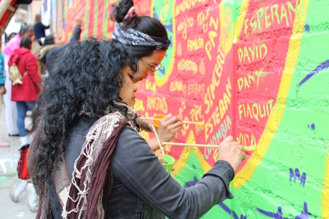 Dos mujeres pintando mural de memoria