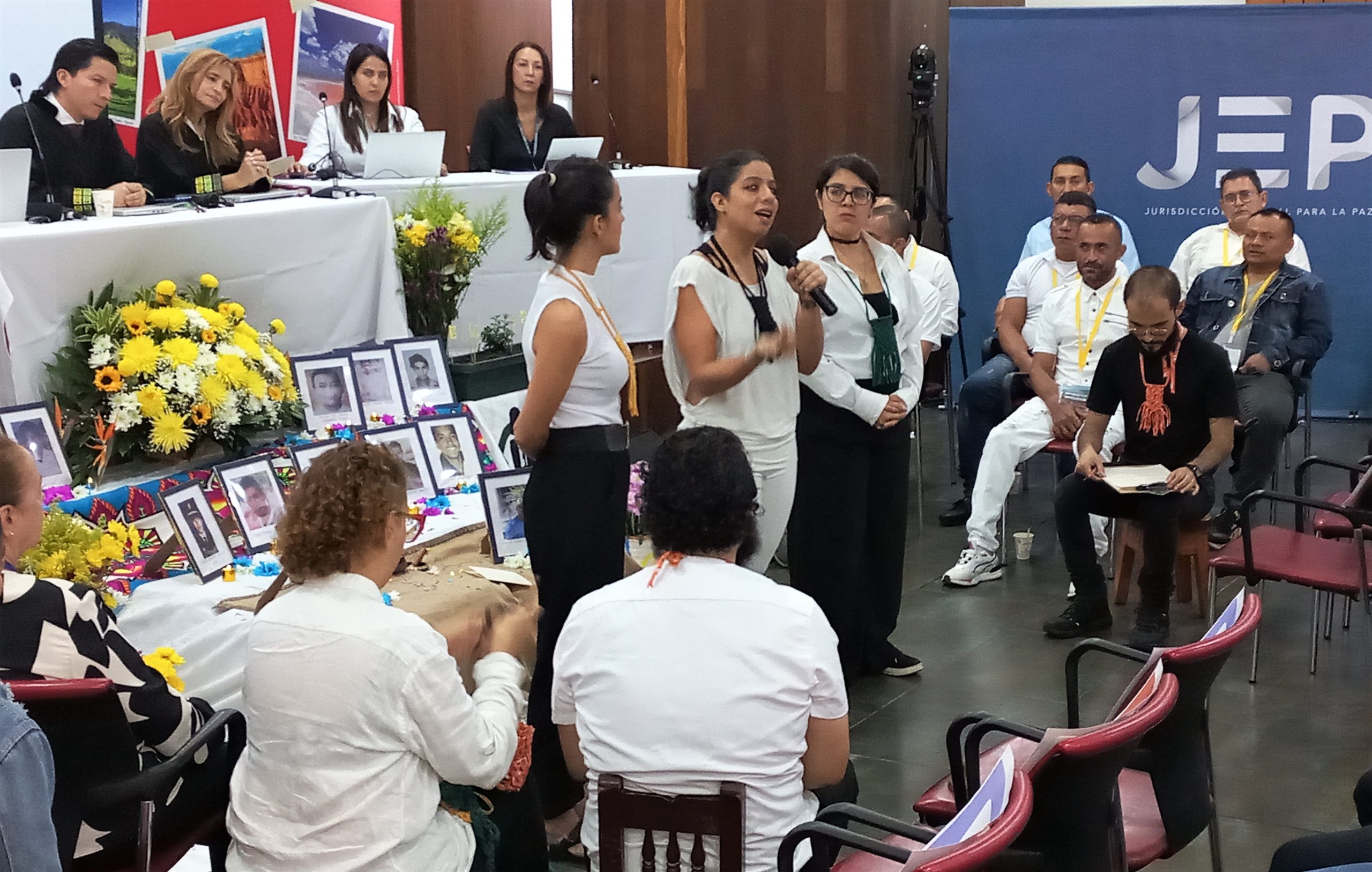 Mujer joven hablando por micrófono frente a grupo de personas