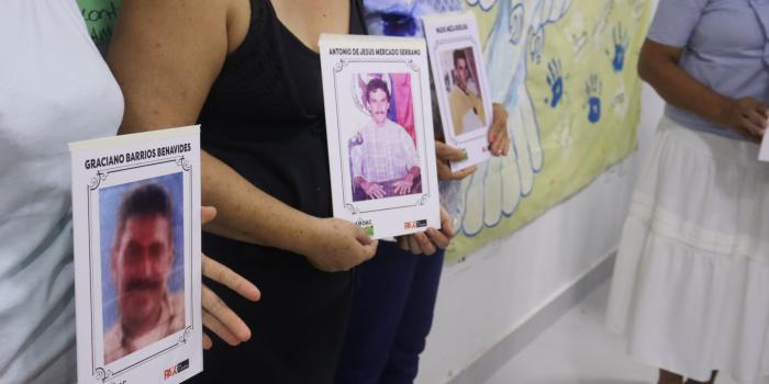 Mujeres sosteniendo fotos de victimas del conflicto armado