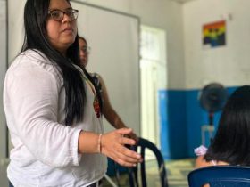 Mujer con camisa blanca mirando a indígenas del Huila