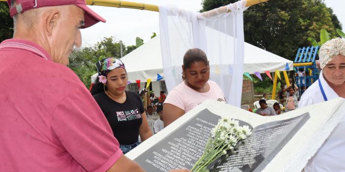 Hombre poniendo flores sobre monumento de memoria