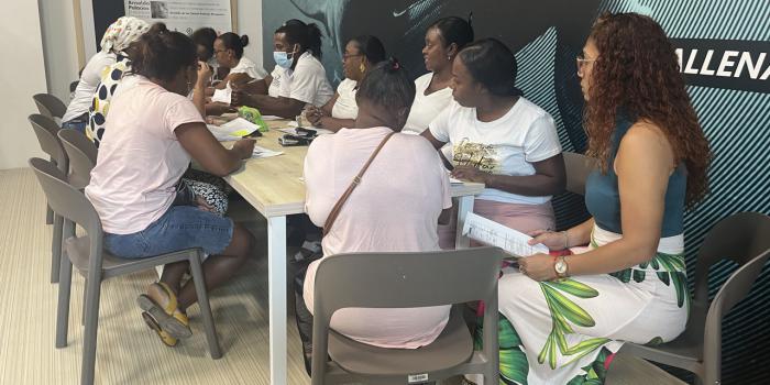 Mujeres afrodescendientes sentadas en mesa socializando entre ellas