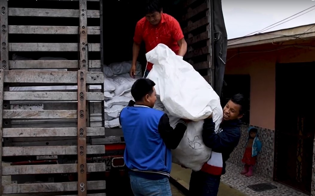 Tres Indígenas descargando bultos de camión