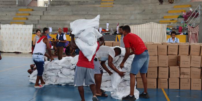 Grupo de hombres cargando bultos con ayuda humanitaria para la comunidad del Bajo Calima