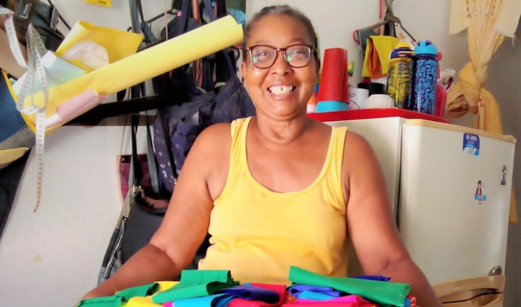 Mujer de tez morena sonriendo desde su taller de confección