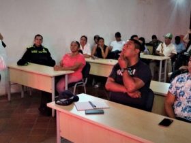 Hombre de camisa blanca hablando por micrófono acerca Planes de Contingencia Humanitaria