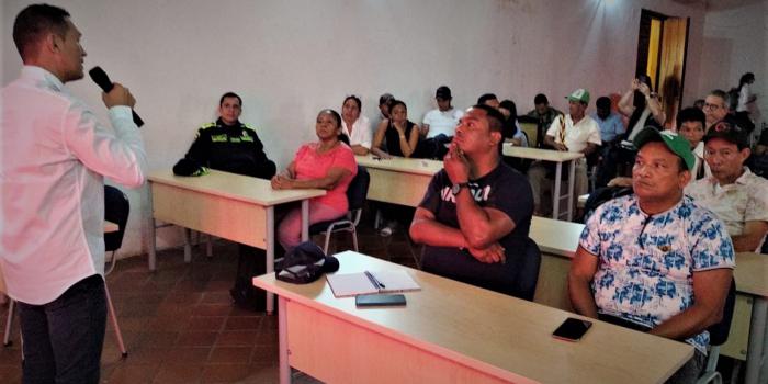 Hombre de camisa blanca hablando por micrófono acerca Planes de Contingencia Humanitaria