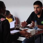 Hombre con camisa negra del Sena socializando con mujer afrodescendiente