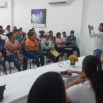 Mujer hablando frente a grupo de víctimas