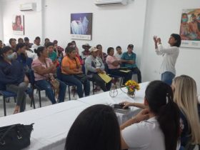 Mujer hablando frente a grupo de víctimas