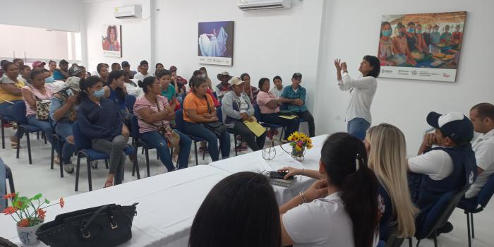 Mujer hablando frente a grupo de víctimas