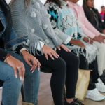 Mujeres víctimas del conflicto sentadas con sus manos sobre las piernas