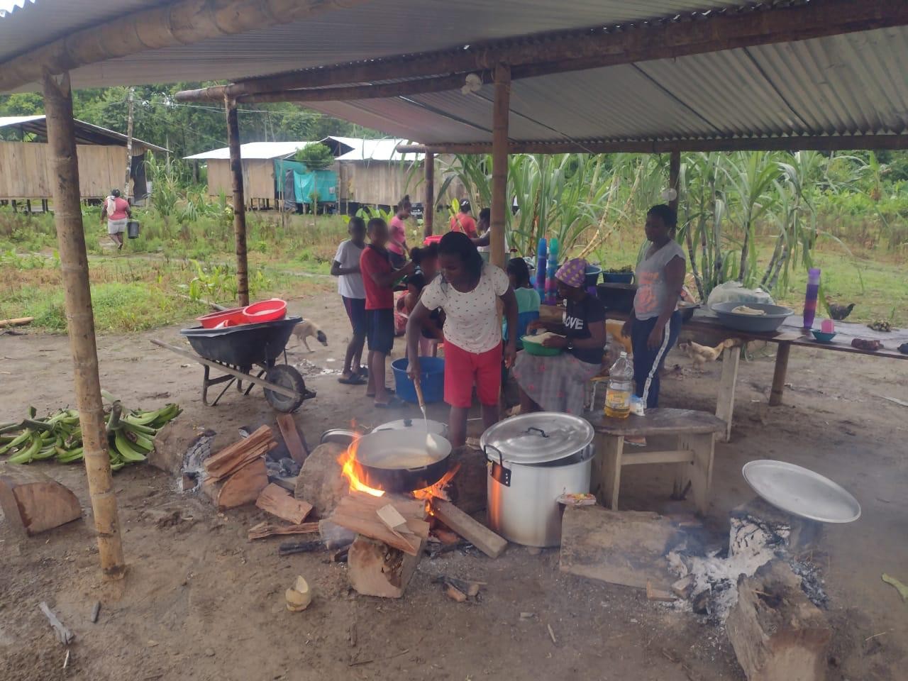Personas afrodescendientes reunidas cocinando sancocho