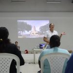 Mujuer exponiendo con proyector videobean a grupo de personas de San Onofre