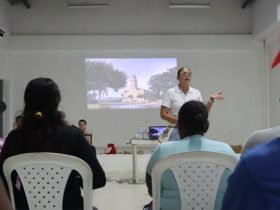 Mujuer exponiendo con proyector videobean a grupo de personas de San Onofre