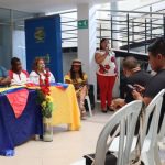 Mujer hablando por micrófono frente a participantes de Municipio de Suáre