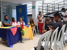 Mujer hablando por micrófono frente a participantes de Municipio de Suáre