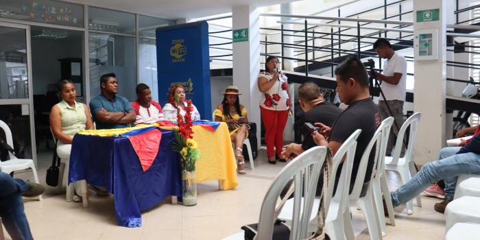 Mujer hablando por micrófono frente a participantes de Municipio de Suáre