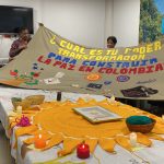 Grupo de personas sosteniendo tejido con símbolo del poder transformador para construir la paz en Colombia