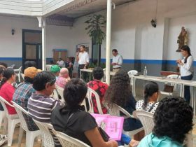 Hombre hablando por microfono a grupo de personas en Santander