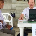 Hombre de la tercera edad siendo atendido por funcionario de La Unidad