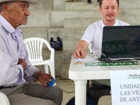 Hombre de la tercera edad siendo atendido por funcionario de La Unidad