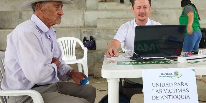 Hombre de la tercera edad siendo atendido por funcionario de La Unidad