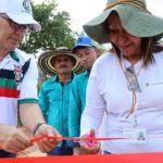 Hombre y mujer cortando cinta roja de inaguracion