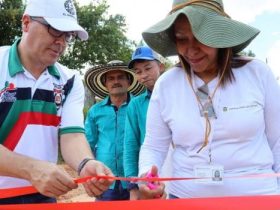 Hombre y mujer cortando cinta roja de inaguracion