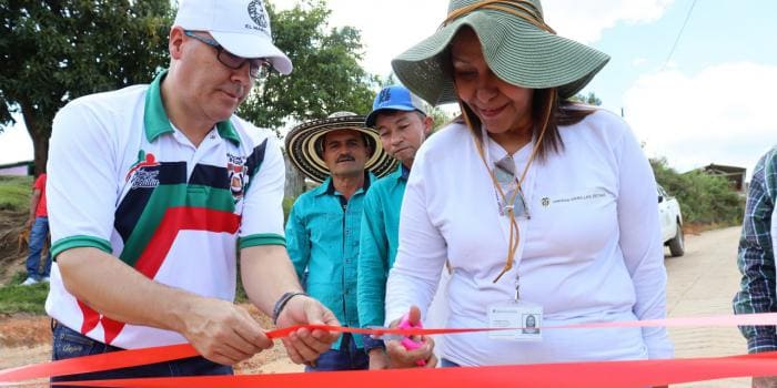 Hombre y mujer cortando cinta roja de inaguracion