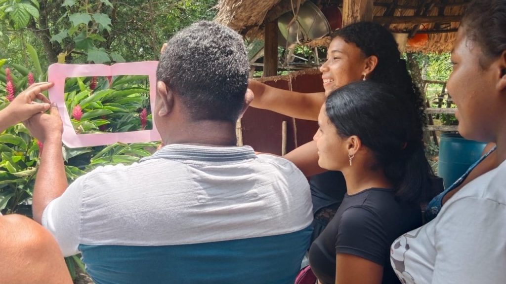 Hombre de espalda sosteniendo con sus manos recuadro de papel