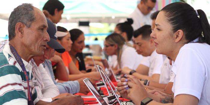 Grupo de personas siendo atendidas por funcionarios