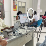 Hombre con gorra roja siendo atendido por funcionario en jornada de identificación