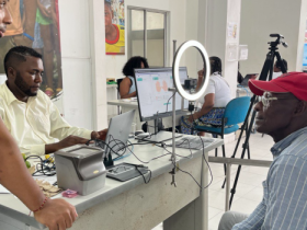 Hombre con gorra roja siendo atendido por funcionario en jornada de identificación