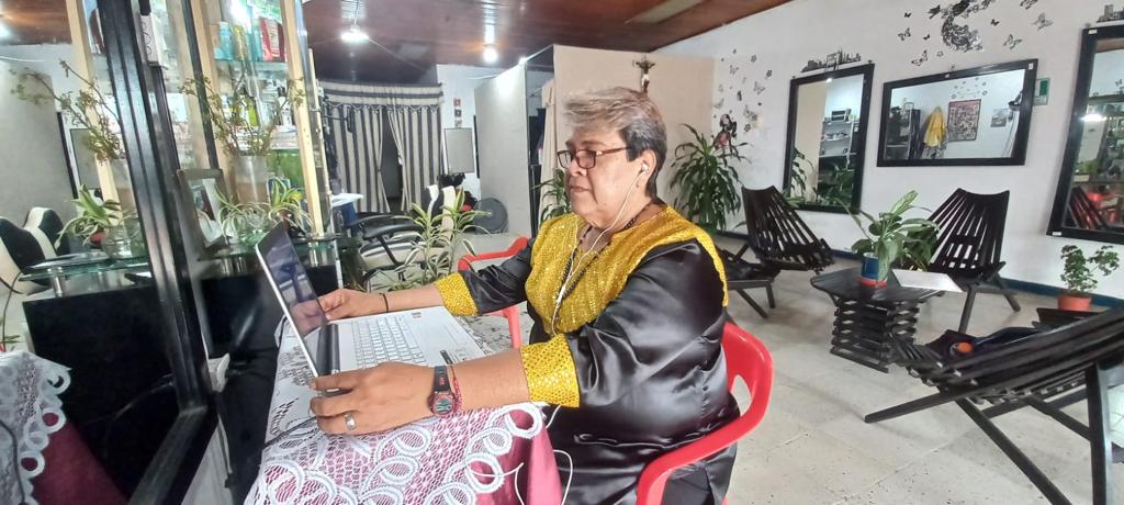 Isabella viendo hacia la pantalla de su computador en la sala de una casa