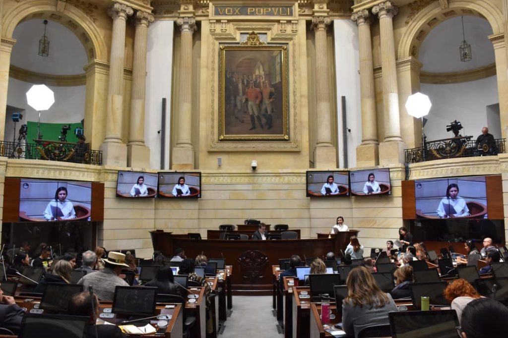 Cubículos con computadores y personas en recinto del congreso