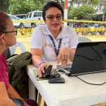 Funcionaria de La Unidad atendiendo a mujer frente a un computador