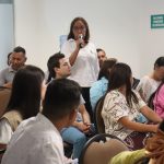 Mujer hablando por microfono en un auditorio