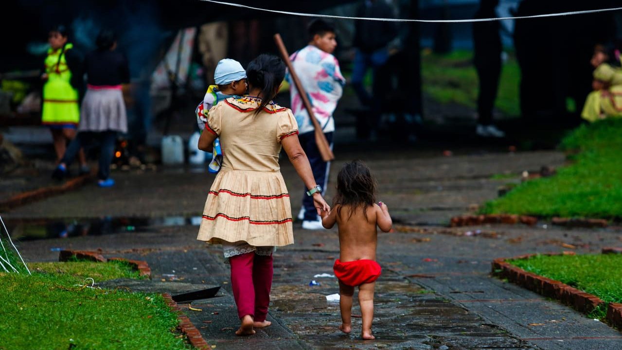 Indigenas caminando en medio de parque